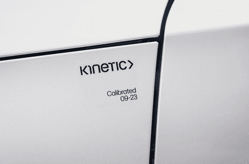 A Kinetic calibration certification sticker on a white car. The sticker reads “Kinetic: calibrated in September, 2023.”